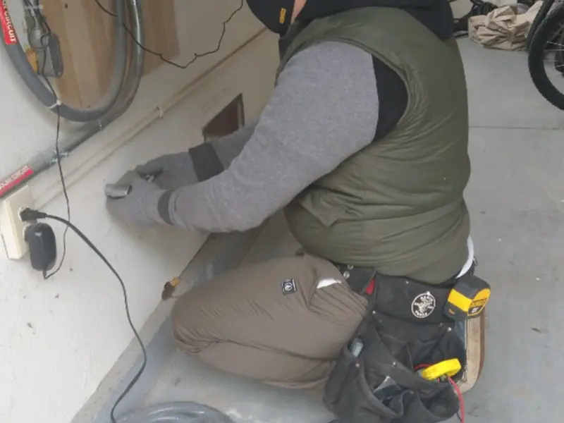 Electrician performing outlet wiring in a Lorton garage